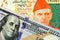 A close up image of a Pakistani rupee bank note with an American one hundred dollar bill