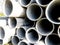 Close up image of pile grey steel pipes at the construction site. Industrial background