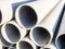 Close up image of pile grey steel pipes at the construction site. Industrial background
