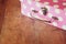 Close up image of pink suitcase with polka dots over wooden table