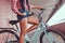 Close-up image of smooth slim female legs in blue sneakers near the city bike