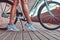 Close-up image of smooth slim female legs in blue sneakers near the city bike