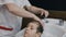 Close-up. Image of stylish male barber washing hair of his little client for making modern haircut in barbershop