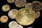 A close up image of Turkish coins and a gold American one ounce coin on a black background