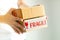 Close-up image of two hands holding two parcel boxes on white background; selective focus