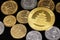 A close up image of West African Franc coins and a gold Chinese one ounce coin on a black background