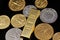 A close up image of West African Franc coins and a gold one ounce ingot on a black background
