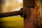 Close up image of a wire boundary rope welded to a metal pole to create a safety boundary in a wooded area