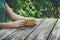 Close up image of woman drinking coffee outdoors, next to wooden table at afternoon. filtered image. selective focus