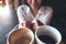 Close up image of a woman holding two white coffee mugs