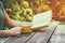 Close up image of woman reading book outdoors, next to wooden table and coffe cup at afternoon. filtered image. filtered image