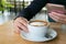 Close-up image of woman take time at coffee shop with a cup of hot latte and her mobilephone