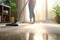 A close-up image of a young maid using a vacuum cleaner to clean a carpet at home.