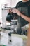 Close up image Young male barista pouring boiling water from kettle for filter coffee