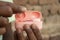 Close-up of an Indian man\'s hand holding a pink wireless