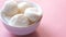 Close up of indian sweet in a white bowl on pink background