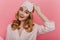 Close-up indoor portrait of ecstatic white girl in eyemask smiling on bright background. Fashionable young woman in cute