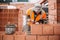 Close up of industrial bricklayer worker placing bricks on cement while building exterior walls