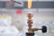 Close up of inoculation loop being sterilized in flame of gas bunsen burner in a laboratory