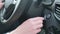 Close up inside modern car, a woman`s hand presses the engine start button. The girl driving