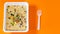 Close up of instant noodles with spices on orange background. Macaroni with spices brewed in boiling water