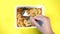 Close up of instant noodles with spices on yellow background. Woman`s hand screwing macaroni on fork.