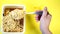 Close up of instant noodles with spices on yellow background. Woman`s hand stirring fork with macaroni.