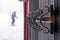 Close-up of iron black ski and snowboard hooks covered with frost on the brown wooden wall of the house