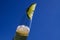 Close up of isolated bottleneck with sparkling yellow beer and a slice of lime against cloudless deep blue sky