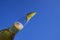 Close up of isolated bottleneck with sparkling yellow beer and a slice of lime against cloudless deep blue sky