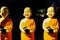 Close up of isolated bright shining sculptures of three happy young boy novice monks