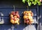 Close up of isolated bunch of onions hanging in bright sun on wooden wall of farm house - Netherlands