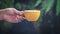 Close-up isolated hand holding yellow mug on black background. hand hold simple yellow cup. Perfect for both tea and coffee