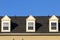 Close up isolated image of three false dormer windows gabbled style on a shingles covered roof