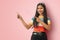 Close-up isolated portrait of charming cute adorable shine cheerful cheery Indian Asian girl pointing aside to copy space