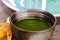 Close up of isolated set for brewing green Matcha tea: one bamboo whisk and scoop, ceramic bowl on old wood table