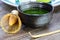 Close up of isolated set for brewing green Matcha tea: one bamboo whisk and scoop, ceramic bowl on old wood table