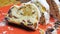 Close up of isolated sliced christstollen with raisins, white powdered sugar and marzipan on red plate