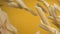 Close-up of Italian pasta penne falling on a yellow background