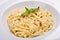 Close-up italian pasta plate with grated parmesan and bas