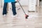 Close-up Of Janitor Sweeping Hardwood Floor