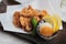 Close-up Japanese deep fried Chicken Karaage with cooking paper served with tempura sauce Tentsuyu mixing mince radish.