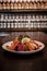 Close-up of Japanese food mixed Sashimi salad dish on wood table with blurred sake bottles rows on shef background, thinly sliced