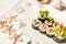 Close-up of Japanese Veggie Futomaki Sushi Roll pieces with fresh vegetables on carton delivery takeaway box on wooden background