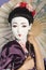 Close-up of Japanese woman with painted face holding parasol