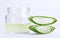 Close up jar of aloe vera gel with sliced aloe vera leaf isolated on white background with clipping path.