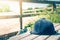 Close up of jockey`s hat laid over wooden bench in front of horse stable fence.