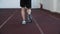 Close up jogger legs in sports sneakers running on treadmill in gym back view. Sportsman running on treadmill on cardio