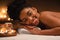 Close up of joyful black lady laying at spa salon