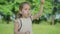 Close-up of joyful Caucasian girl with brown eyes blowing soap bubbles and talking. Charming cheerful little child